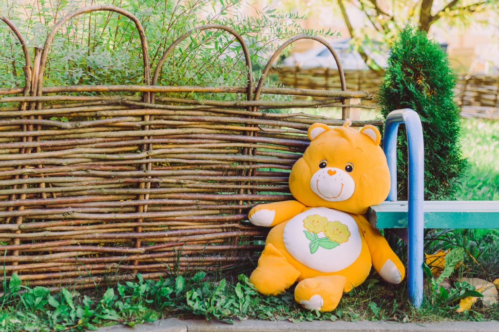 Yellow Teddy bear doll sitting on the ground
